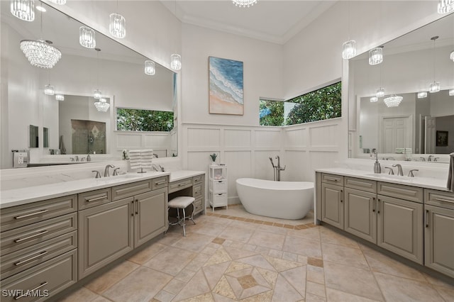 24221 Addison Place Ct, Bonita Springs, FL 34134 - full bath featuring a decorative wall, inlaid floor details, two vanities, a freestanding tub, and wainscoting