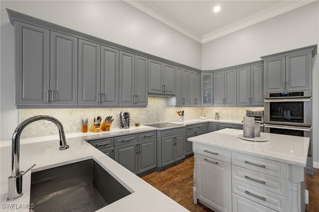 24221 Addison Place Ct, Bonita Springs, FL 34134 - kitchen featuring gray cabinets, stainless steel double oven, ornamental molding, glass insert cabinets, and backsplash