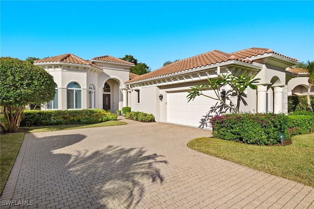 24221 Addison Place Ct, Bonita Springs, FL 34134 - mediterranean / spanish-style home with a garage, stucco siding, driveway, and a tiled roof