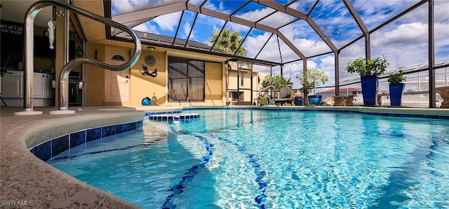 pool with glass enclosure and a patio