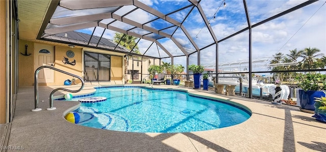 outdoor pool with glass enclosure and a patio area