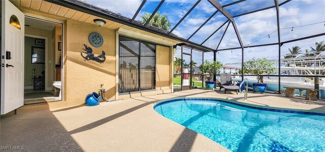 outdoor pool with glass enclosure and a patio