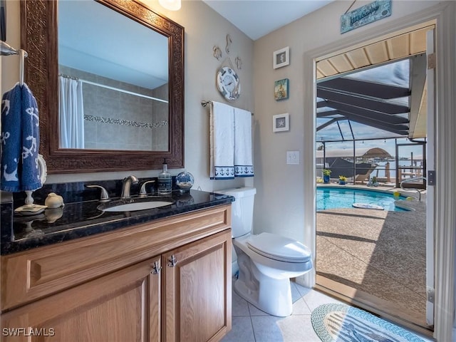 bathroom with toilet, curtained shower, tile patterned flooring, and vanity