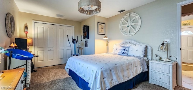 carpeted bedroom with visible vents and a closet