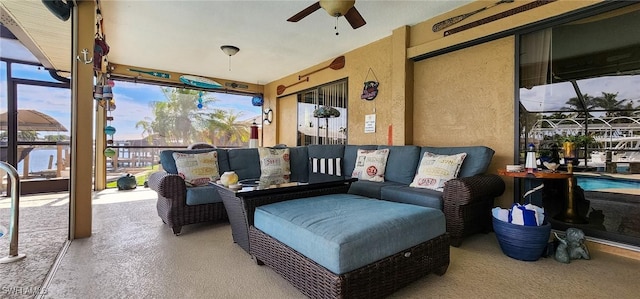 view of patio / terrace featuring glass enclosure and a ceiling fan