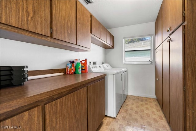 clothes washing area featuring cabinets and washing machine and dryer