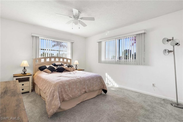 carpeted bedroom featuring ceiling fan, multiple windows, and a textured ceiling