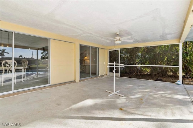 unfurnished sunroom featuring ceiling fan