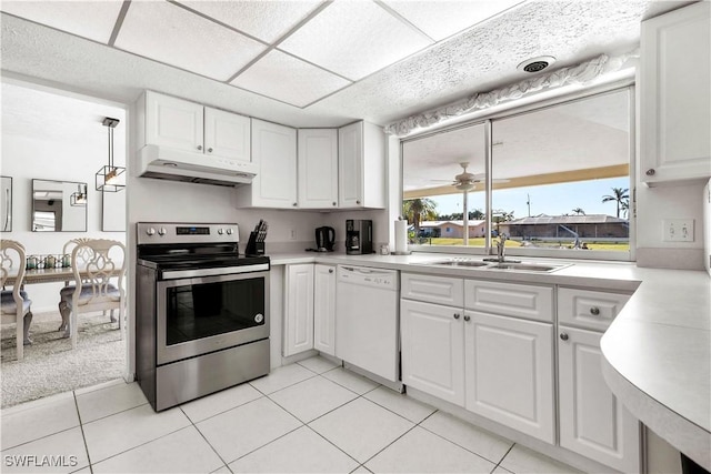 kitchen with white dishwasher, sink, stainless steel electric range, and white cabinets