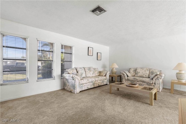 carpeted living room featuring a textured ceiling