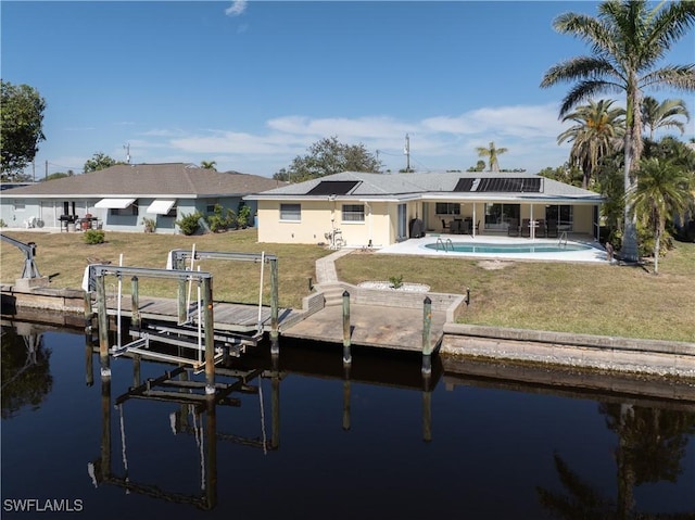 view of dock featuring a patio, a water view, and a yard