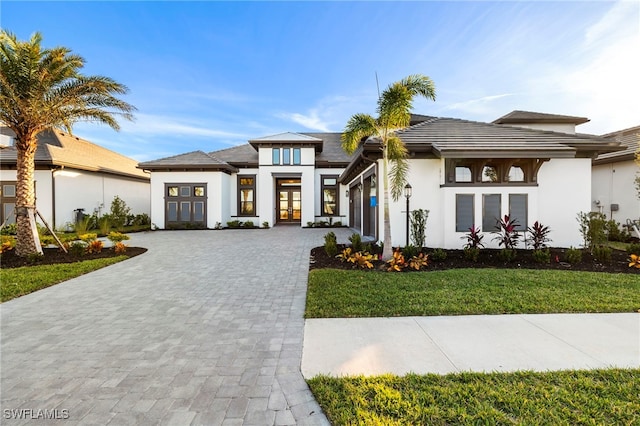 prairie-style house featuring a front yard and french doors