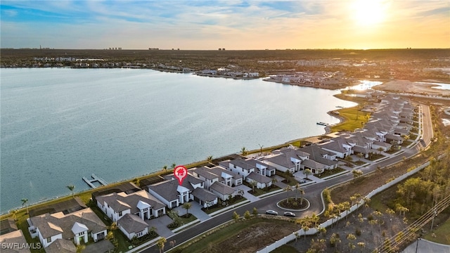 aerial view at dusk featuring a water view