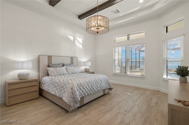 bedroom with beamed ceiling, a high ceiling, a chandelier, and light hardwood / wood-style flooring