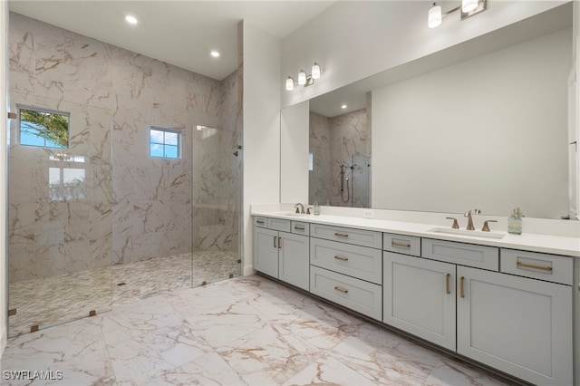 bathroom with a tile shower and vanity