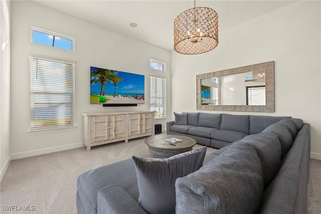 living room with carpet flooring, a wealth of natural light, and a chandelier