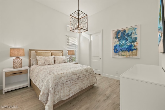 bedroom featuring a chandelier and light hardwood / wood-style floors