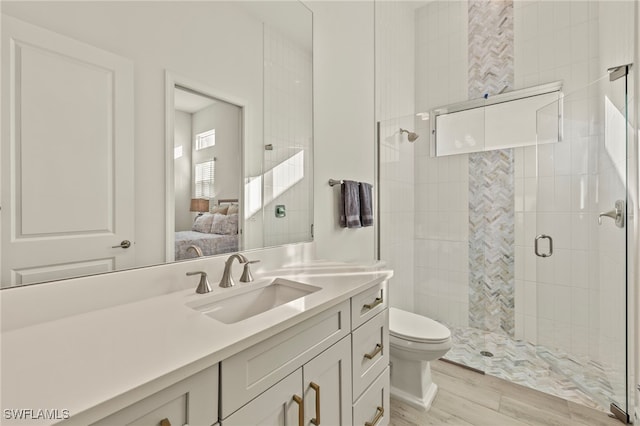 bathroom with walk in shower, hardwood / wood-style floors, vanity, and toilet