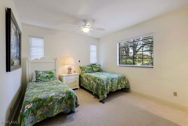 4556 Pond Apple Dr N, Naples, FL 34119 - bedroom featuring multiple windows, light carpet, and ceiling fan