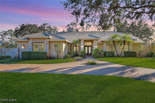4556 Pond Apple Dr N, Naples, FL 34119 - view of front of property featuring french doors, a front yard, stucco siding, and a chimney