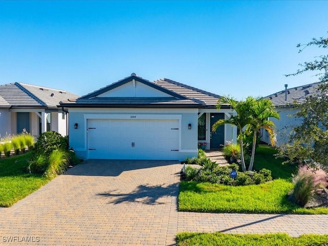 ranch-style home with a garage and a front lawn