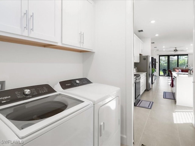 laundry room featuring cabinets, ceiling fan, light tile patterned flooring, and washing machine and dryer