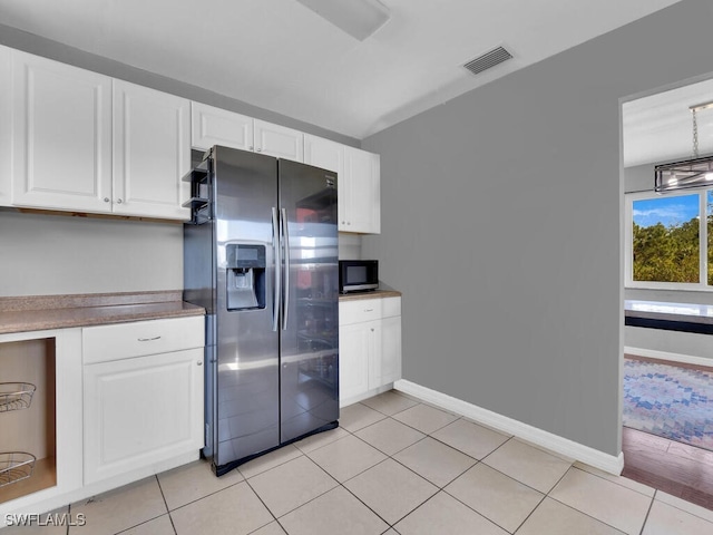 kitchen featuring white cabinets, light tile patterned floors, and stainless steel appliances