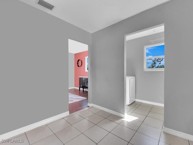 tiled spare room featuring washer / dryer