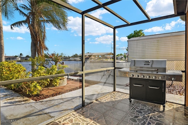 sunroom featuring a water view