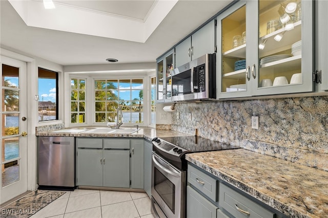 kitchen with gray cabinetry, sink, appliances with stainless steel finishes, and tasteful backsplash