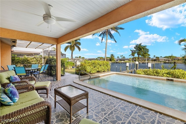 view of pool featuring ceiling fan, a patio area, and a water view