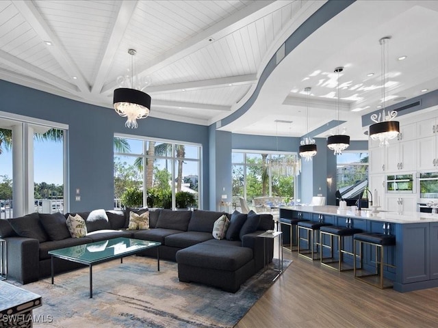 living room featuring beam ceiling, sink, dark hardwood / wood-style flooring, and a notable chandelier