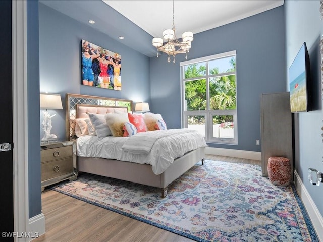 bedroom with a chandelier and light hardwood / wood-style floors