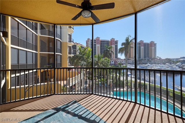 balcony featuring ceiling fan and a water view