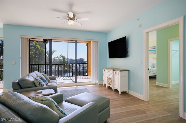 living room with ceiling fan and light hardwood / wood-style flooring