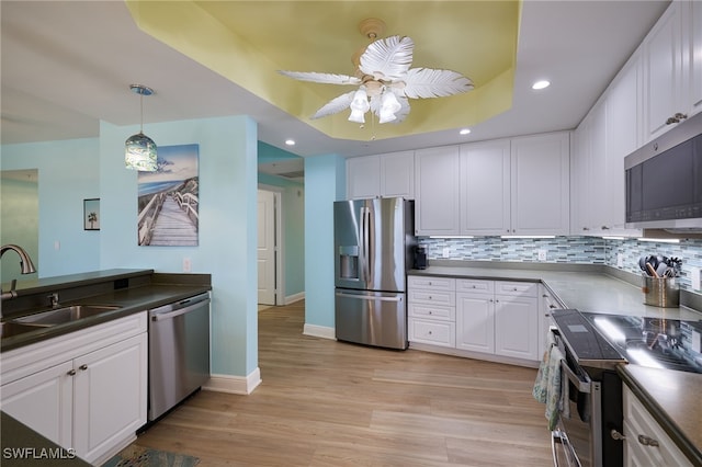 kitchen featuring ceiling fan, sink, stainless steel appliances, light hardwood / wood-style flooring, and white cabinets