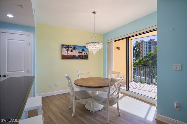 dining space with hardwood / wood-style floors and a chandelier