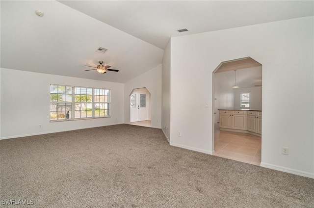 unfurnished living room with ceiling fan, light carpet, and vaulted ceiling