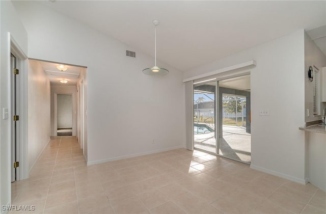 unfurnished dining area with light tile patterned flooring and vaulted ceiling