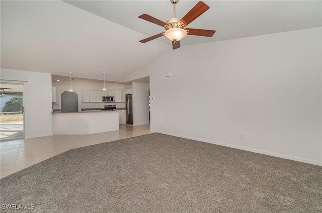 unfurnished living room with ceiling fan, sink, light tile patterned floors, and vaulted ceiling