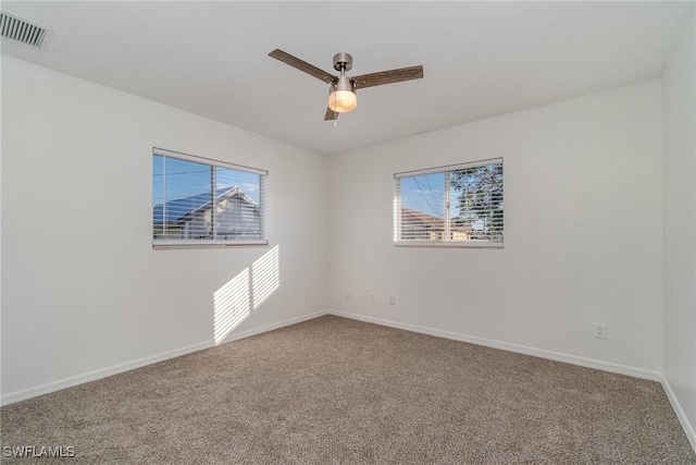 carpeted spare room with plenty of natural light and ceiling fan