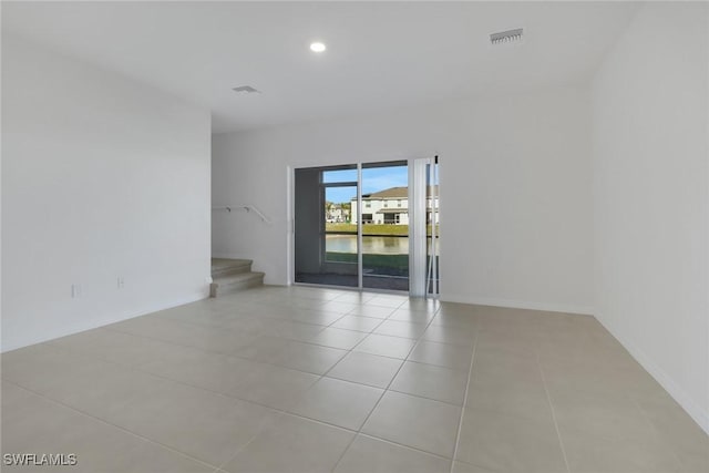 spare room with a water view and light tile patterned flooring