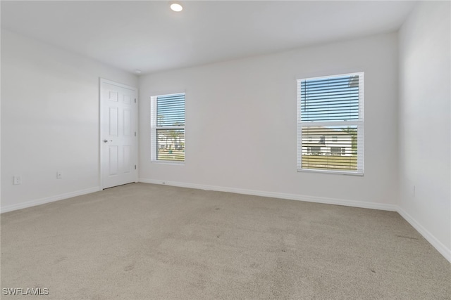 unfurnished room with a wealth of natural light and light carpet