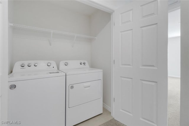 laundry area featuring light carpet and washer and dryer