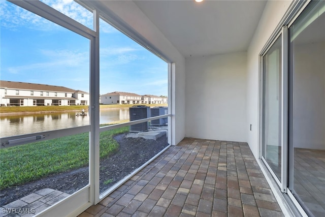 unfurnished sunroom featuring a water view