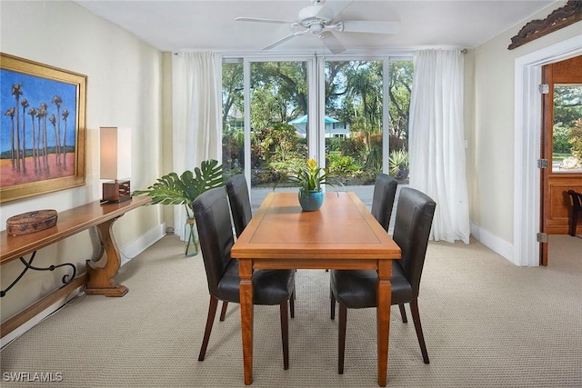 dining space featuring ceiling fan and light carpet