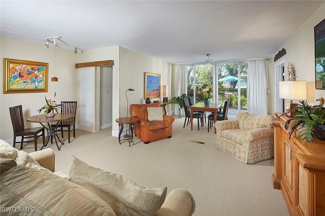 living room with rail lighting, light colored carpet, and ceiling fan