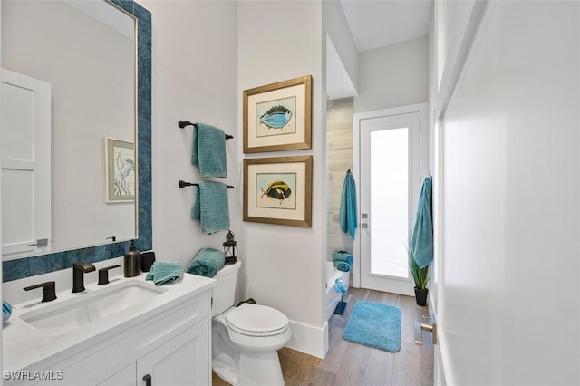 bathroom featuring baseboards, vanity, toilet, and wood finished floors