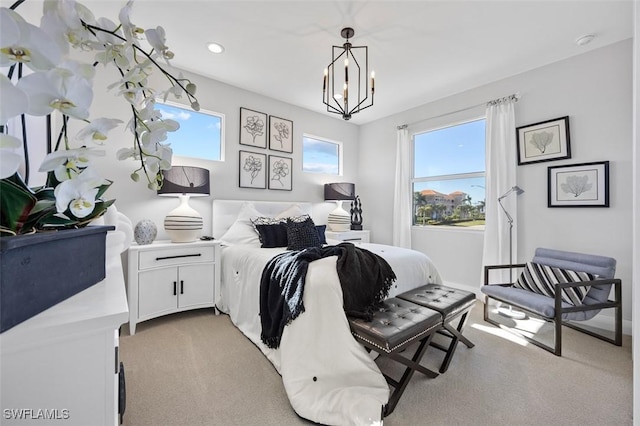 bedroom with a chandelier and light colored carpet