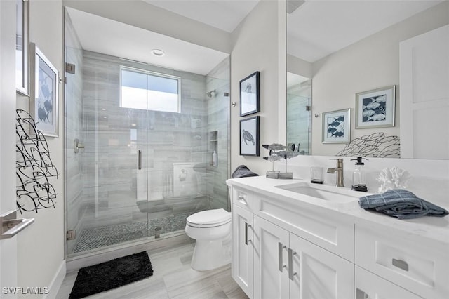 bathroom featuring a shower with door, vanity, and toilet